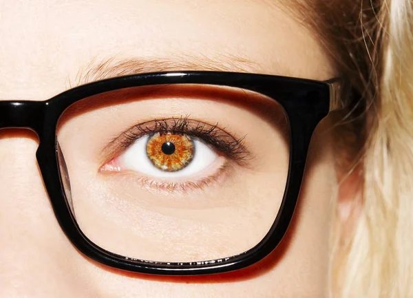 Um olhar bonito e perspicaz olho de mulher. Mulher a usar óculos. Imagem de close-up — Fotografia de Stock