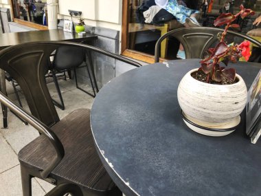 Demir tablo ana cadde üzerinde bir kafede. Masaya çiçek