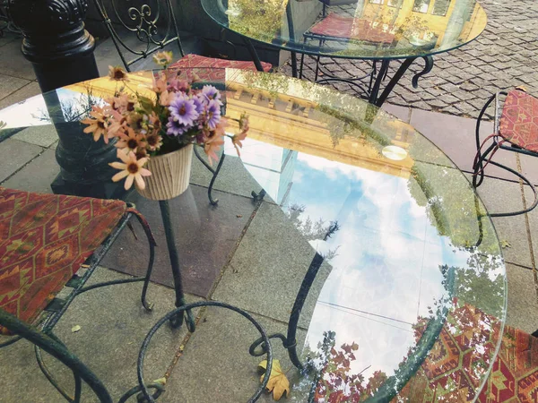Szklany stolik w kawiarni przy głównej ulicy. Reflection Niebo i drzewa — Zdjęcie stockowe