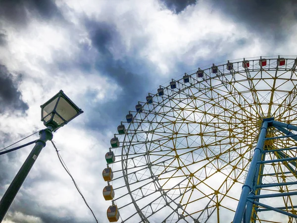 A breathtaking view of the ferris wheel against the sky from the bottom of the top of Mtatsminda Park on the funicular in Tbilisi — Stock Photo, Image