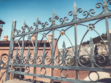 Tbilisi binalar sokakta. Güzel Iron gate karşı tuğla duvar yaz gün