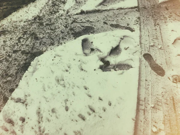 Rastros de neumáticos del coche y zapatos en la nieve. El comienzo del invierno en Bakuriani — Foto de Stock