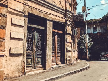TBILISI, GEORGIA - 10 Temmuz 2018: Yazın eski Tiflis mimarisi, bahçesi, pencereleri, çiçekleri ve yeşil yaprakları