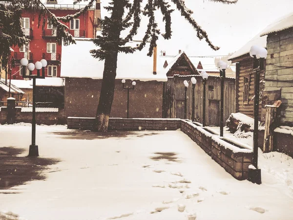 Snörika vintern middagstid. Snötäckta träden, taken i små hus på gården. Mountain ski resort Bakuriani — Stockfoto