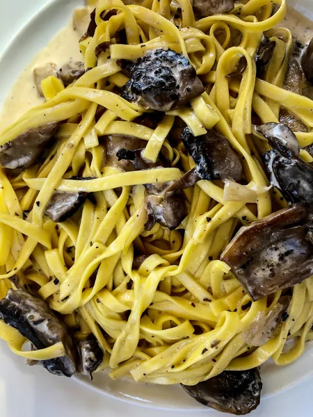 Tagliatelle con funghi e salsa alla panna da vicino . — Foto Stock