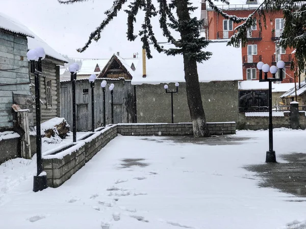 Snörika vintern middagstid. Snötäckta träden, taken i små hus på gården. Mountain ski resort Bakuriani — Stockfoto