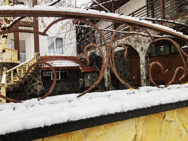 Stenen utfärda utegångsförbud för med dekorativa stål trim. Snöfall på gatan. Noon — Stockfoto