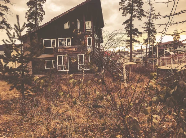 Pequena casa de campo de madeira na floresta de montanha de outono. Floresta com árvores nuas e folhas de outono laranja caídas secas. Bakuriani — Fotografia de Stock