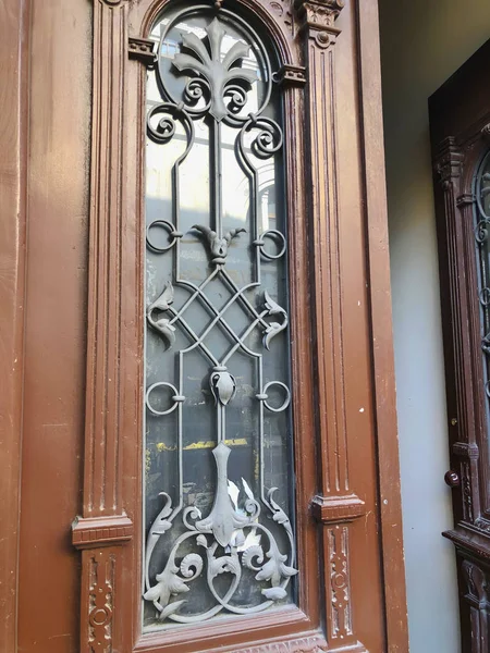 Puerta de madera de cristal de un edificio en la calle con un adorno decorativo de hierro. Arquitectura antigua de Tiflis — Foto de Stock