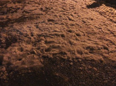 Yolda kar. Lastikler araç ve karda ayakkabı izleri. Bakuriani kışın başında