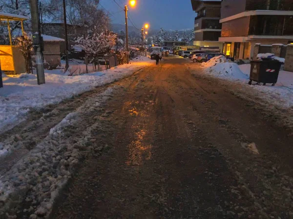 Vägen, delvis rensas från snö. Spår av däck från bilen i snön. Början av vintern i Bakuriani — Stockfoto