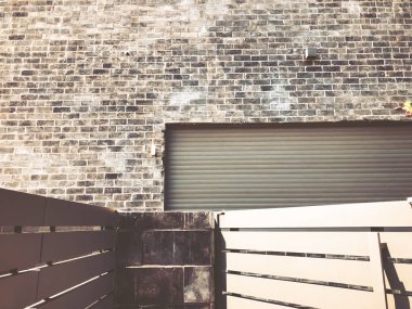 Karanlık tuğla duvar ve ahşap çit. Siyah taş duvar doku