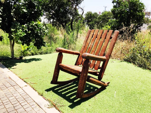 Дерев'яне крісло-качалка на газоні навколо будинку — стокове фото