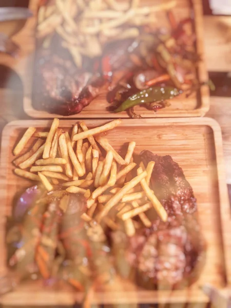 Rimmad Oxbringa med pommes frites, grönsaker och ketchup på en träbricka — Stockfoto