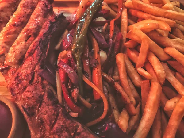 Patatine fritte, verdure e ketchup su un vassoio di legno — Foto Stock