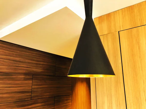 Svart dekorativ lampa hänger från taket. En modern ljuskrona hemma. — Stockfoto