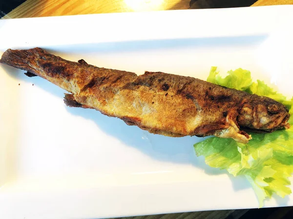 Ahşap masa üzerinde kızarmış balık. Gürcü mutfağı — Stok fotoğraf