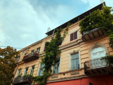 Güzel eski Tiflis eski şehir dar sokakta kısmen yapraklı balkon Georgia ev.