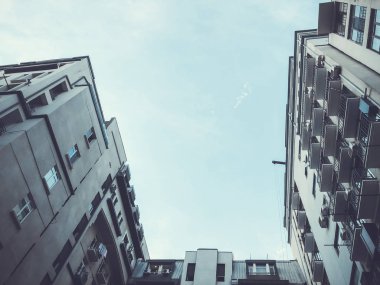 Aşağıdan gökyüzüne doğru yükselen bir binanın görüntüsü.