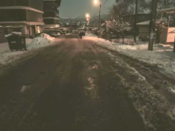 A estrada, parcialmente limpa de neve. Vestígios de pneus do carro na neve. O início do inverno em Bakuriani — Fotografia de Stock