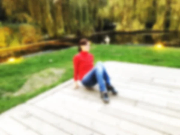 Atractiva chica elegante en una blusa roja posando en un parque junto al estanque. Día de otoño en el parque. Efecto Blure —  Fotos de Stock