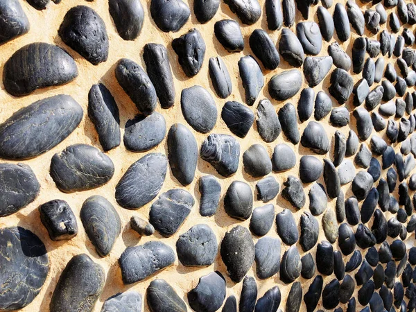 Round stone paving. Natural stone masonry top view. Seaside pebble photo texture