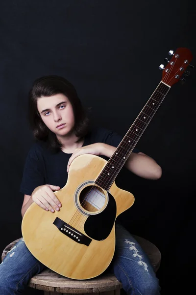 Portrait of a teenager playing guitar in studio. — Stock Photo, Image