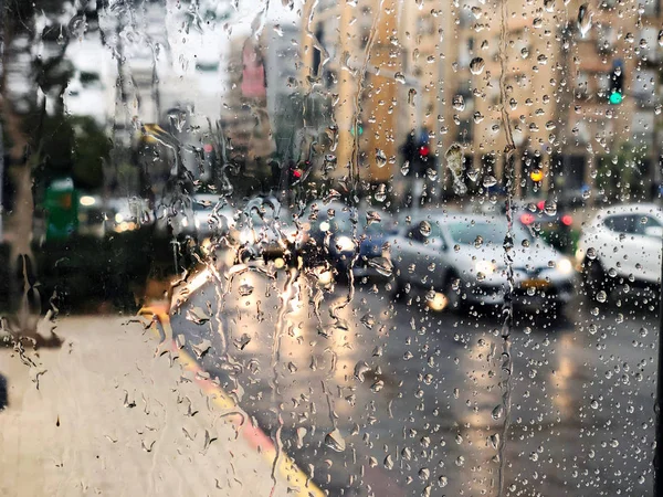 Deszczowa samochodu i oświetlenie uliczne, postrzegane przez szyby na ruchliwej ulicy w nocy — Zdjęcie stockowe