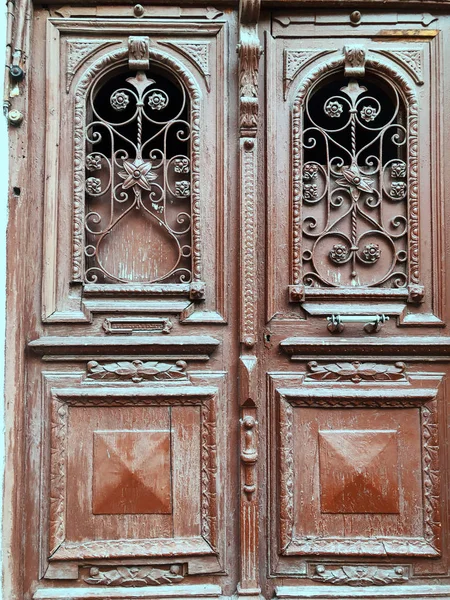 Houten deur van een gebouw in de straat met een ijzeren decoratieve ornament. Oude Tbilisi architectuur — Stockfoto