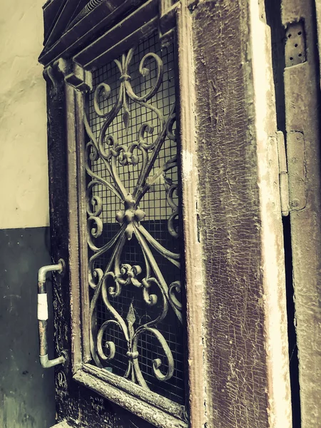 Porte en bois d'un bâtiment dans la rue avec un ornement décoratif en fer. Ancienne architecture de Tbilissi — Photo