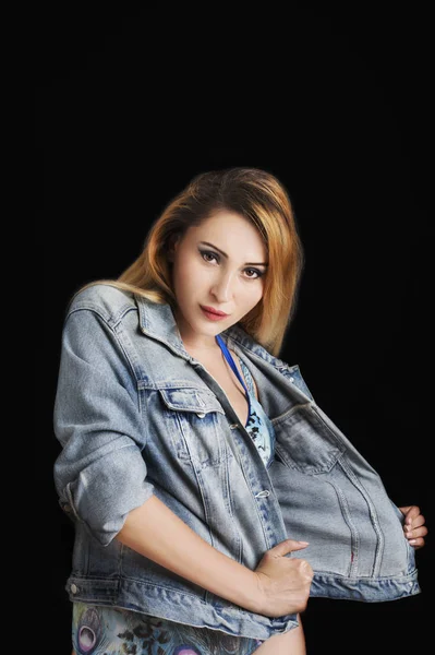 Menina sexy bonita jovem posando em jaqueta de jeans e maiô na moda. Estúdio . — Fotografia de Stock