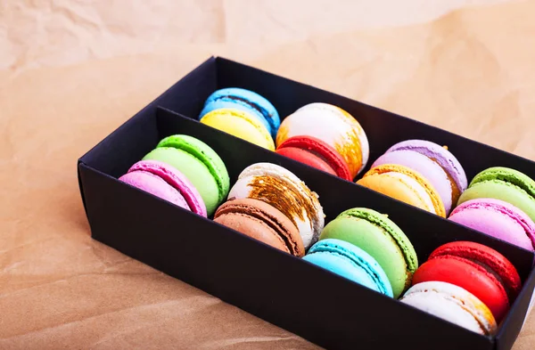 Tasty different colored macarons in black box on light background — Stock Photo, Image