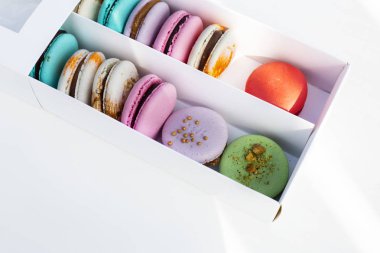 Hafif arka planda beyaz kutuda lezzetli farklı renkli makarnalar
