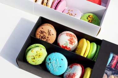 Hafif arka planda beyaz ve siyah kutularda lezzetli farklı renkli makarnalar