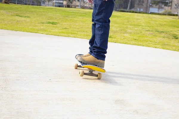 Mladý americký skateboardista nohy na koni skateboard na skatepark. — Stock fotografie