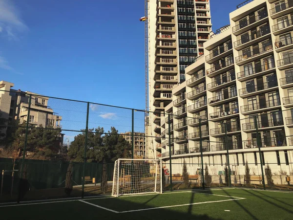 Portas de futebol para o campo de esportes no pátio da cidade no fundo de um novo edifício residencial — Fotografia de Stock