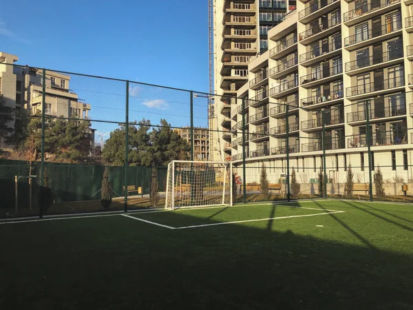 Portas de futebol para o campo de esportes no pátio da cidade no fundo de um novo edifício residencial — Fotografia de Stock