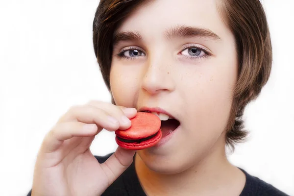 Bello ragazzo mangiare maccheroni su sfondo bianco . — Foto Stock