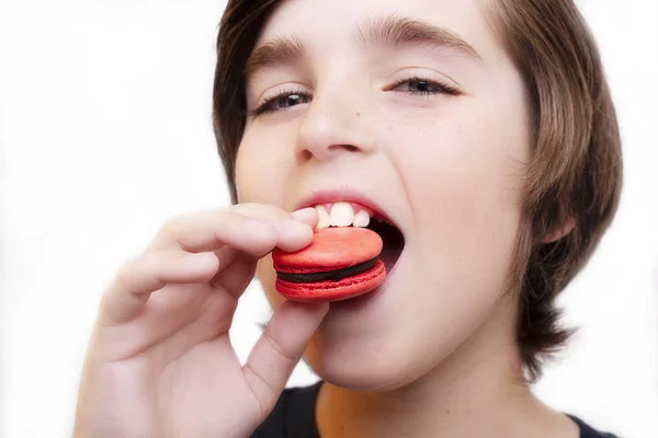 Schöner Junge isst Makkaroni auf weißem Hintergrund. — Stockfoto