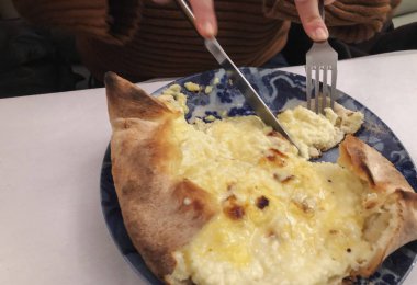 Gürcü ulusal mutfağı - tabakta taze pişmiş adjarian khachapuri. Bıçak khachapuri tarafından kesilen kız