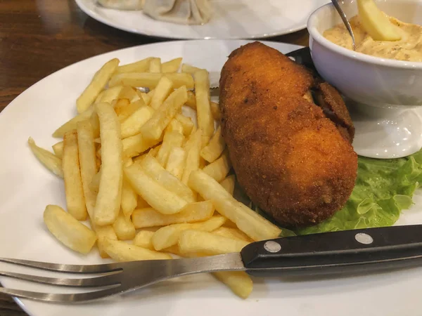 Escalope traditionnelle à Kiev avec pommes de terre dans une assiette, Poulet Kiev. Nourriture savoureuse, escalopes aux frites, sauce dans une casserole — Photo