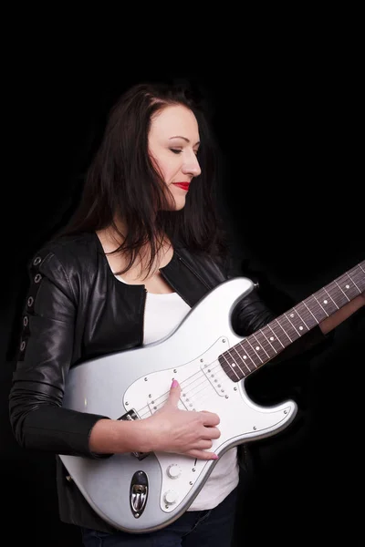 Beautiful dark girl playing guitar in rock style on a black background. — Stock Photo, Image