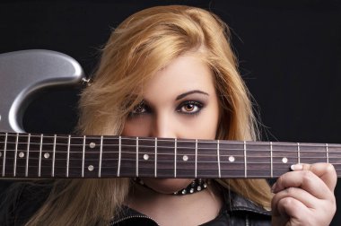 Gitar rock tarzında bir siyah arka plan üzerinde güzel sarışın kız.