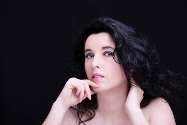 Uzun siyah saçlı, esmer, çekici bir kadın.