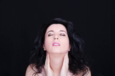 Uzun siyah saçlı, esmer, çekici bir kadın.