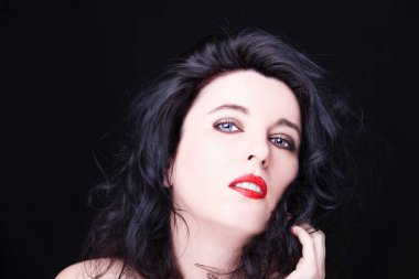 Karanlık arka planda genç ve çekici bir kadının portresi.