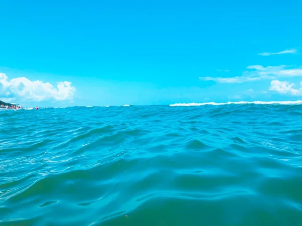 Primer plano de las olas marinas. Vista frontal sobre hermosa ola marina en la playa de arena. Día soleado de verano, cielo azul, fondo de agua —  Fotos de Stock