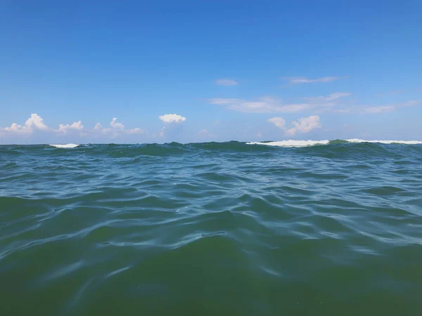 Близько морської хвилі. Вид спереду на красиву морську хвилю на піщаному пляжі. Літній сонячний день, блакитне небо, водяний фон — стокове фото