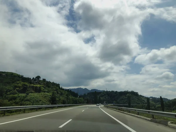 Cloudy sky, clouds, view from the car on the road. Road trip