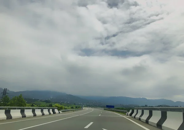 Cloudy sky, clouds, view from the car on the road. Road trip — Stock Photo, Image